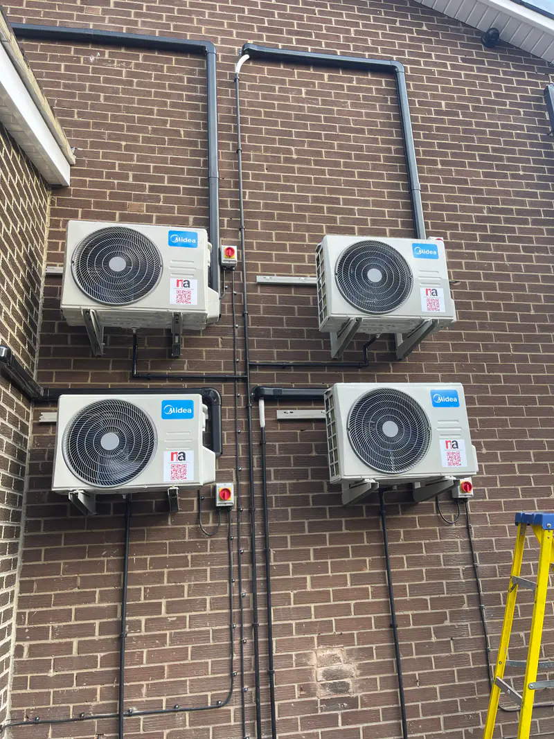Planned air conditioning maintenance in York Four outdoor air conditioning units on a commercial building wall in York with neat trunking