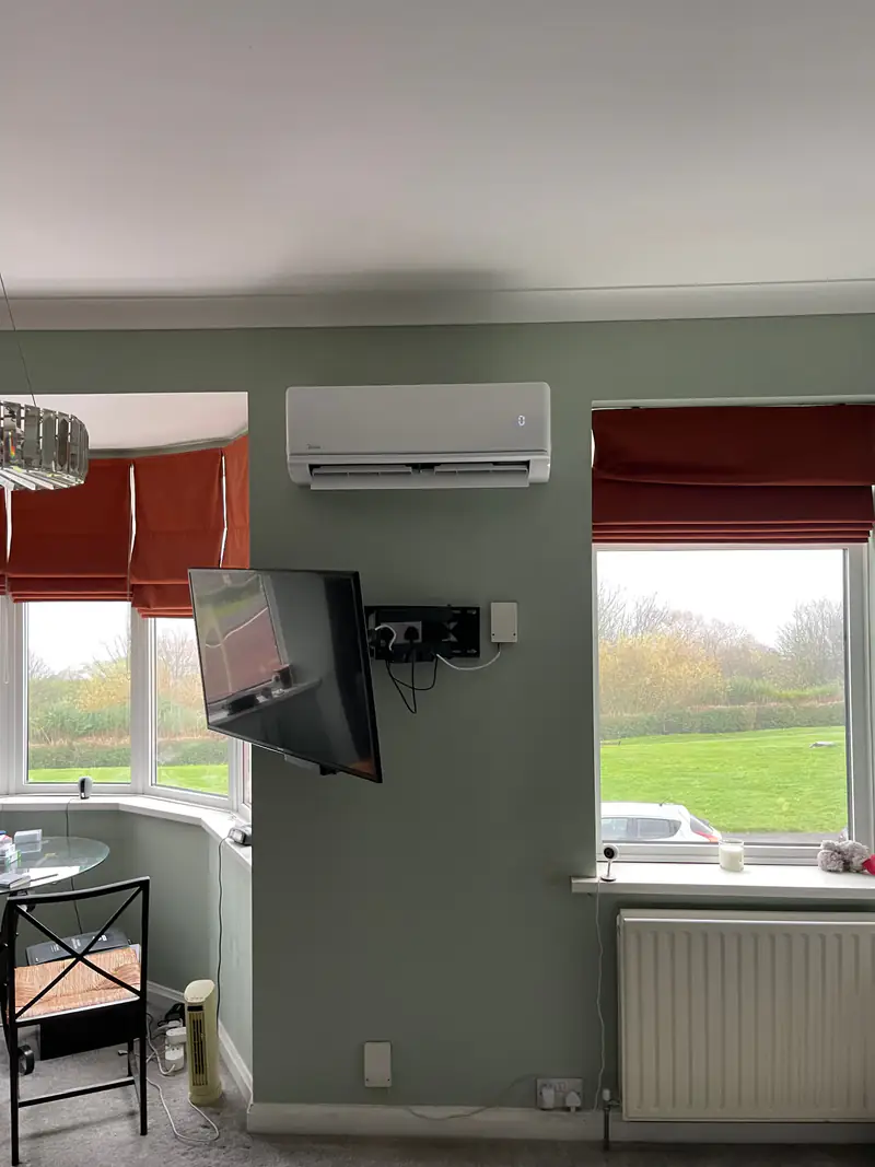 Air conditioning in Pocklington Wall-mounted air conditioning unit in a sage-green dining room with a bay window in a Pocklington home