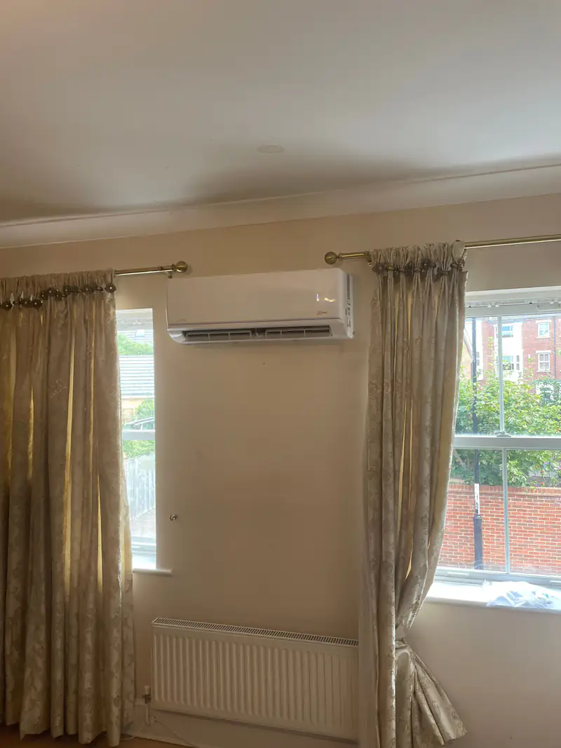 Air conditioning in Tadcaster Wall-mounted air conditioning unit above a bedroom window in a stone-built Tadcaster house